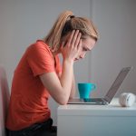 Furloughed woman at desk looking at laptop